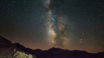 The Milky Way lighting up the night sky with a mountain.